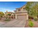Exterior of a two-story home showing manicured landscaping, a balcony, and an attached two-car garage at 10965 Ladyburn Ct, Las Vegas, NV 89141