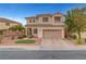Two-story house with a beige exterior, a tile roof, and a two-car garage in a well-kept neighborhood at 10965 Ladyburn Ct, Las Vegas, NV 89141