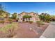 Front exterior of a two-story house with desert landscaping, a covered entryway, and a side-entry two-car garage at 10965 Ladyburn Ct, Las Vegas, NV 89141