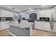 Bright kitchen with stainless steel appliances, granite counters, white cabinets and an arched window over the stovetop at 10965 Ladyburn Ct, Las Vegas, NV 89141