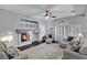 Bright living room with a fireplace, ceiling fan, stylish furniture, and lots of natural light at 10965 Ladyburn Ct, Las Vegas, NV 89141