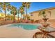 Backyard features refreshing pool, water fountain, mature palm trees, and desert landscaping at 10965 Ladyburn Ct, Las Vegas, NV 89141