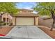 Two-car garage and driveway with desert landscaping at 11016 Meadow Leaf Ave, Las Vegas, NV 89144
