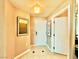 Hallway with neutral walls and floors with artwork leads to the front door at 135 E Harmon Ave # 2916, Las Vegas, NV 89109