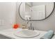 Close-up of the vanity featuring an oval mirror, fresh towel, and flower decorated soap at 1437 Price St, Henderson, NV 89011