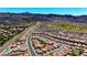 Expansive aerial view of a community with numerous homes, streets, and mountain views at 1803 Eagle Village Ave, Henderson, NV 89012