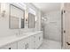 Luxurious primary bathroom featuring double sinks, framed mirrors, and a glass-enclosed shower with stunning tile work at 1803 Eagle Village Ave, Henderson, NV 89012