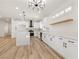 A modern kitchen with white cabinets, stainless steel appliances and large kitchen island at 1803 Eagle Village Ave, Henderson, NV 89012