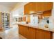 Bright kitchen featuring wood cabinets, tiled countertop and a breakfast bar offering ample space and functionality at 2040 Tucuman Ave, Pahrump, NV 89048