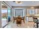 Bright dining area with tile flooring, bay window, and sliding glass door to the backyard at 2116 Burtonsville Dr, Henderson, NV 89044