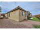 Exterior of tan home featuring rock landscaping, shutters, and a tile roof at 2116 Burtonsville Dr, Henderson, NV 89044