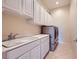 Laundry room featuring a sink, granite counter, and stainless steel washer and dryer at 2116 Burtonsville Dr, Henderson, NV 89044
