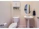 Well-lit powder room with pedestal sink, toilet, and stylish fixtures at 2116 Burtonsville Dr, Henderson, NV 89044