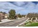 Neighborhood street view with mature trees, landscaping, and blue skies at 2116 Burtonsville Dr, Henderson, NV 89044