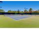 Well-maintained tennis court with professional lighting and a shaded seating area at 2116 Burtonsville Dr, Henderson, NV 89044