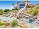 Stunning waterfall feature cascading down a rocky landscape into a serene pond at 2116 Burtonsville Dr, Henderson, NV 89044