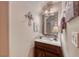Cozy powder room features a granite countertop, dark wood cabinets, and decorative mirror at 2853 Blythswood Sq, Henderson, NV 89044