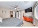 Bedroom featuring a ceiling fan, TV, dresser, and doorway to a bathroom creating a comfortable and functional space at 2853 Blythswood Sq, Henderson, NV 89044