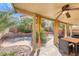 Covered patio with ceiling fan and backyard landscaping with multiple seating areas at 2853 Blythswood Sq, Henderson, NV 89044