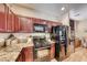 Stylish kitchen featuring granite counters, dark cabinetry, stainless steel appliances, and wine storage at 2853 Blythswood Sq, Henderson, NV 89044