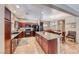 Well-equipped kitchen with dark wood cabinets, granite countertops, a center island, and modern appliances at 2853 Blythswood Sq, Henderson, NV 89044