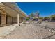 Covered patio area in the backyard, surrounded by rock landscaping and mature trees at 3017 Walnut Park Ct, Henderson, NV 89052