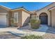 Close-up of the front entrance featuring a tiled roof, arched doorway, and well-maintained desert landscaping at 3017 Walnut Park Ct, Henderson, NV 89052