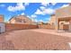 Expansive backyard featuring gravel landscape, walled perimeter, and a brick patio, perfect for entertaining at 309 Gemstone Hill Ave, North Las Vegas, NV 89031
