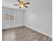 A bright bedroom featuring a ceiling fan and a window, with wood-look flooring at 309 Gemstone Hill Ave, North Las Vegas, NV 89031