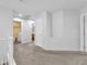 Spacious hallway with neutral carpet, white walls, and views of a laundry room and other rooms at 309 Gemstone Hill Ave, North Las Vegas, NV 89031