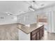 Open kitchen concept with granite counters, brown cabinets, a center island, and an island light at 309 Gemstone Hill Ave, North Las Vegas, NV 89031