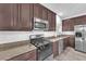 Close-up of kitchen featuring stainless appliances, granite countertops, and light wood floors at 309 Gemstone Hill Ave, North Las Vegas, NV 89031