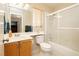 Bathroom featuring a vanity, toilet, and shower-tub combination with glass doors and tile surround at 3360 Cheltenham St, Las Vegas, NV 89129