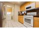 Traditional kitchen with wooden cabinets, white appliances and white tile floors at 3360 Cheltenham St, Las Vegas, NV 89129