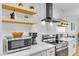 Close up of the kitchen with updated appliances, white countertops, and floating shelving at 3611 Valencia St, Las Vegas, NV 89121