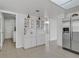 Open kitchen area with tile flooring, white cabinetry, stainless steel appliances, and access to laundry room at 3692 Rawhide Ct, Las Vegas, NV 89120