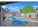 Backyard swimming pool with decorative rock waterfall feature, hot tub, patio area, landscaping and palm trees at 3692 Rawhide Ct, Las Vegas, NV 89120