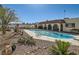 Desert landscaped backyard with a pool, stone patio, and lush greenery at 3788 Forestcrest Dr, Las Vegas, NV 89121