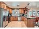 Kitchen featuring stainless steel appliances, wooden cabinetry, tile backsplash, and a granite countertop island at 3788 Forestcrest Dr, Las Vegas, NV 89121