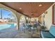 Inviting covered patio with outdoor seating and a view of the sparkling pool and backyard at 3788 Forestcrest Dr, Las Vegas, NV 89121