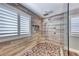 Modern bathroom boasts a walk-in shower featuring pebble floor, rainfall head, and sleek glass enclosure at 3809 Vincelli Ave, North Las Vegas, NV 89031
