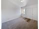 Empty living room with fresh carpet, a window with security bars, and a neutral color scheme at 3829 Soda Springs Dr, Las Vegas, NV 89115