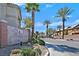 Entrance to Pine Villas with a sign, palm trees and street view of the community at 3920 Sweet Pine St # 102, Las Vegas, NV 89108