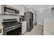 Well-lit kitchen features stainless steel appliances, tile flooring, and white cabinets at 3920 Sweet Pine St # 102, Las Vegas, NV 89108