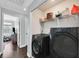 Convenient laundry room equipped with modern black washer and dryer units and extra shelving at 3920 Sweet Pine St # 102, Las Vegas, NV 89108