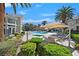Resort style pool area with sun loungers, tables, umbrellas, palm trees and lush green landscaping at 3920 Sweet Pine St # 102, Las Vegas, NV 89108
