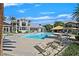 Community pool featuring lounge chairs, sunshades, palm trees, and views of residential buildings at 3920 Sweet Pine St # 102, Las Vegas, NV 89108