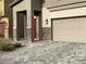 Close up of a home's exterior showing stone accents, a red door, and a well-maintained driveway at 4243 Sago Lily St, Las Vegas, NV 89129