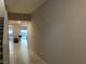 Hallway view with neutral walls and floors leading to a bright living space with tile floors at 4243 Sago Lily St, Las Vegas, NV 89129