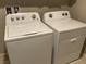 Laundry room with full size Whirlpool washer and dryer, and overhead cabinets for storage at 4243 Sago Lily St, Las Vegas, NV 89129